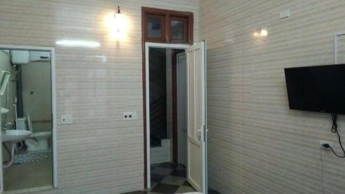 une salle de bain avec une télévision sur un mur dans l'établissement Nhà nghỉ Sao VInh, à Bến Thủy