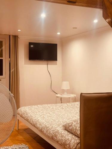 a bedroom with a bed with a flat screen tv on the wall at Faro Coast Guest House in Faro