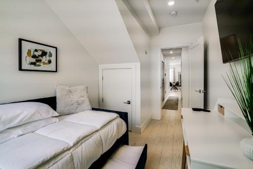 a bedroom with a bed and a white wall at The Luxe 8th St Suite in Washington, D.C.