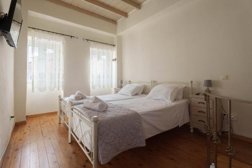 a bedroom with a white bed and a wooden floor at Elia Studio in Sokrákion