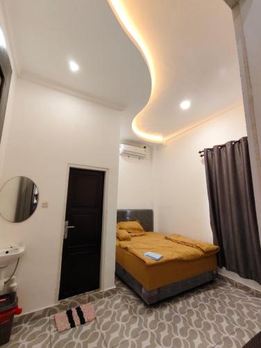 ein kleines Schlafzimmer mit einem Bett und einem Waschbecken in der Unterkunft Wisma Raudah Wakatobi in Mandati