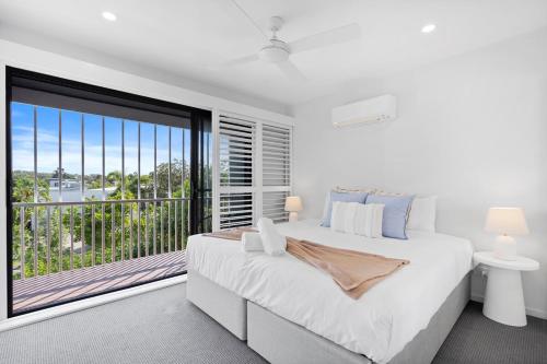 a bedroom with a large bed and a large window at Seabreeze in Kingscliff