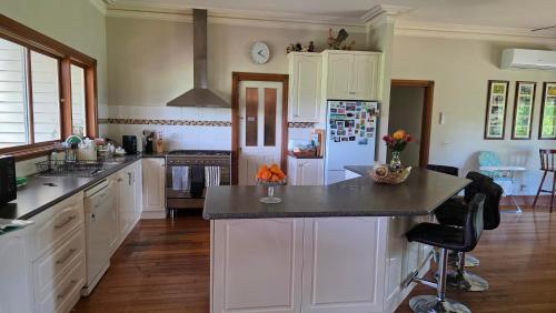 Una cocina con gabinetes blancos y una encimera negra. en Jilly Park Farmstay Experience Discover Authentic Farm Life Complimentary Breakfast Included, en Buln Buln