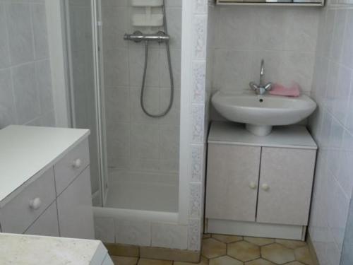 une salle de bain blanche avec une douche et un lavabo dans l'établissement Charmante Maison à Recques-sur-Hem, 2 pers, Animaux Acceptés, Jardin, Proche Calais et St Omer - FR-1-376-58, à Recques-sur-Hem