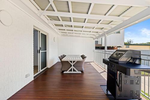 an outdoor patio with a table and a grill at Villa Burra - Pet Friendly - 5 Mins Walk to the Beach in Culburra Beach