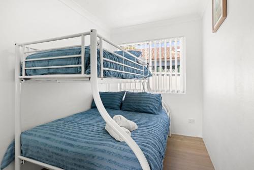 a bedroom with a bunk bed with blue sheets at Villa Burra - Pet Friendly - 5 Mins Walk to the Beach in Culburra Beach