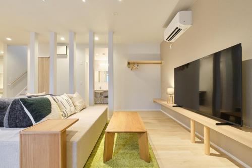 a living room with a large flat screen tv at 星宿 Asahikawa Miyashita in Asahikawa