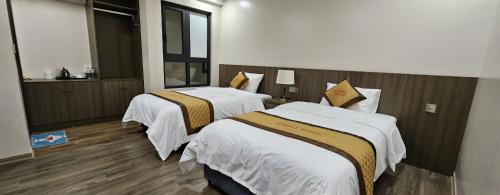 ein Hotelzimmer mit zwei Betten und einem Fenster in der Unterkunft Marina Hotel Lạng Sơn in Kỳ Lừa
