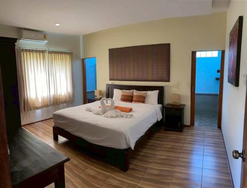 a bedroom with a large white bed in a room at Taratai Villa Guest House in Nong Prue