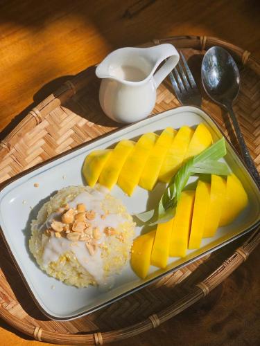 un plato de comida con fruta y una taza de café en InnerZen Riverside homestay Ben Tre 1 bedroom for 1-2 guests, 2 bedrooms for 3-4 guests, en Ấp Phú Hòa (3)