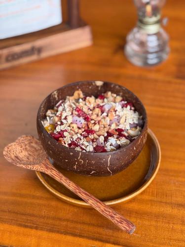 Un tazón de comida sobre una mesa con dos cucharas. en InnerZen Riverside homestay Ben Tre 1 bedroom for 1-2 guests, 2 bedrooms for 3-4 guests, en Ấp Phú Hòa (3)