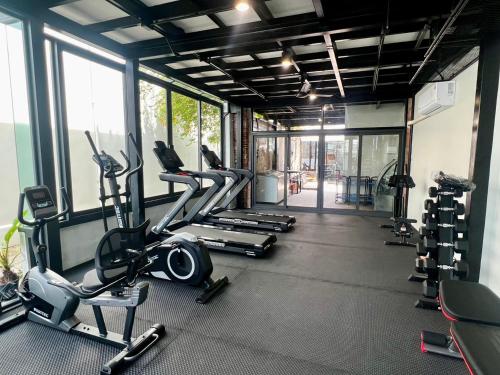 a gym with several treadmills and elliptical machines at Casa Der See Boutique House in Songkhla