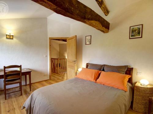 une chambre avec un lit, une table et un bureau dans l'établissement Gîte cosy avec jardin clos et animaux acceptés - FR-1-496-119, à Virigneux