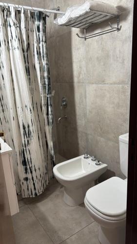 a bathroom with a toilet and a shower curtain at Departamento en Chivilcoy in Chivilcoy