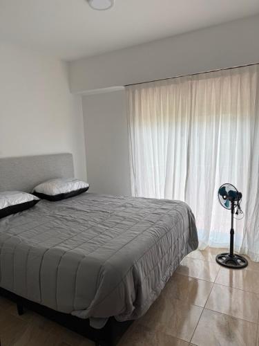 a bedroom with a bed and a large window at Departamento en Chivilcoy in Chivilcoy