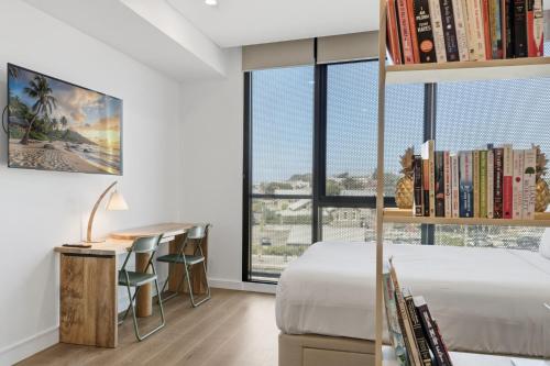 a bedroom with a bed and a desk and a window at Coastal Apartment with Rooftop Pool in North Fremantle