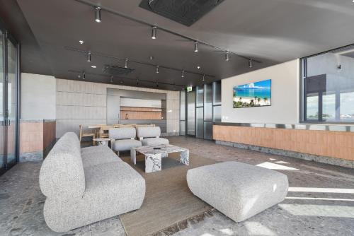 a living room with a couch and chairs and a table at Coastal Apartment with Rooftop Pool in North Fremantle