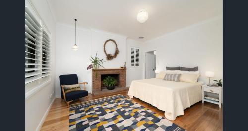 阿米代尔Boutique Cottage on Mann的一间带床和壁炉的白色卧室