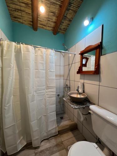 ein Badezimmer mit einem weißen Duschvorhang und einem Waschbecken in der Unterkunft Paraje la bendición in Tilcara