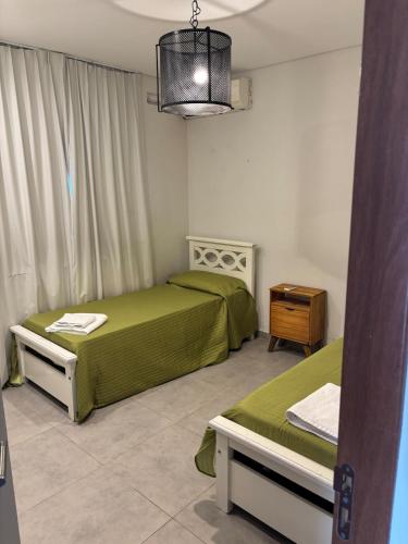 ein Schlafzimmer mit zwei Betten, einem Tisch und einer Lampe in der Unterkunft mirante del cerro in Yerba Buena