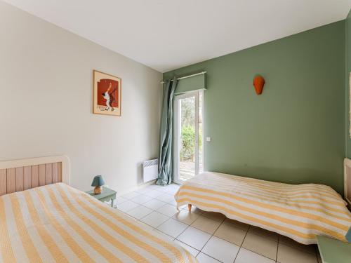 ein Schlafzimmer mit zwei Betten und einem Fenster in der Unterkunft Villa avec piscine privée, jardin clôturé et WIFI à Biscarrosse - Idéale pour 6 personnes - FR-1-521-192 in Biscarrosse