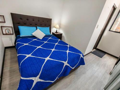 een slaapkamer met een blauw dekbed op een bed bij FLOREZ APT6 - Céntrico, acogedor con calefacción in La Paz