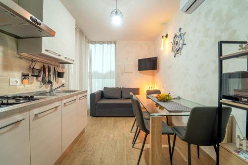 una cucina e un soggiorno con un tavolo e un divano di La Perla di Marzamemi a Marzamemi