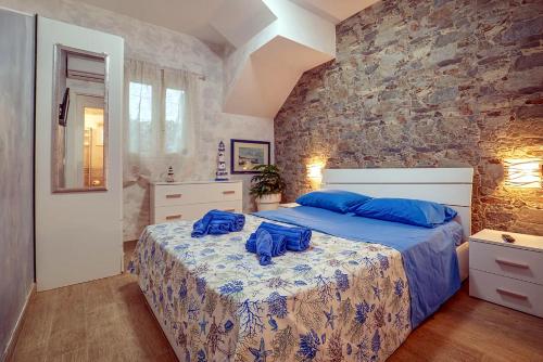 a bedroom with a bed with blue pillows on it at La Perla di Marzamemi in Marzamemi