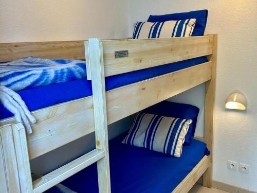 a couple of bunk beds in a room at Maison confortable 6 pers, terrasse, résidence avec piscine et parking proche mer - FR-1-239-1118 in Ondres