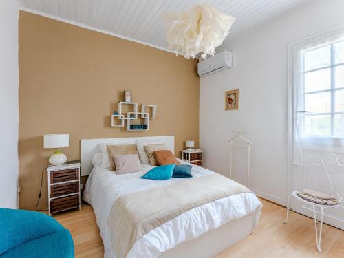 a bedroom with a large white bed and a chandelier at Maison Landaise Charme Proche Océan, Animaux Acceptés - FR-1-521-254 in Biscarrosse