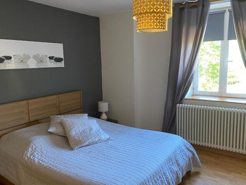 une chambre avec un lit avec une couette bleue et une fenêtre dans l'établissement Gîte spacieux avec piscine et terrasse en village - FR-1-589-637, à Hennecourt