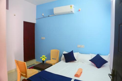 ein Schlafzimmer mit einem Bett mit einer blauen Wand in der Unterkunft Balaji home stay in Puducherry