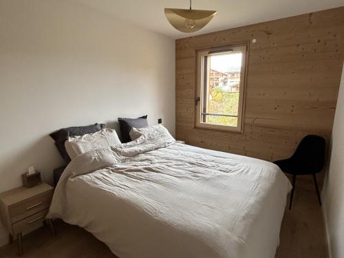 a bedroom with a white bed and a window at Nouveau ! Appartement de standing 3 chambres avec balcon et parking couvert - FR-1-836-42 in Les Carroz d'Araches