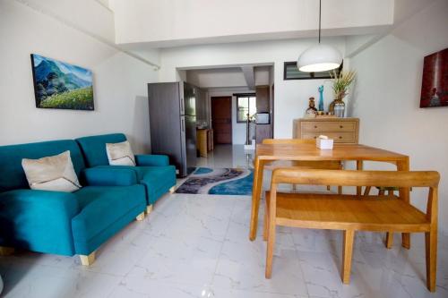 a living room with a blue couch and a table at Lazy shot in Ban San Ton Ko (1)