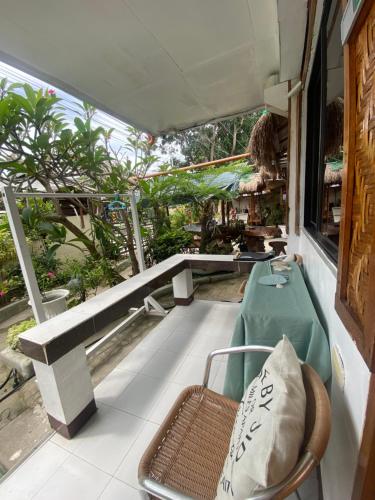 a porch with a bench and a chair on a balcony at Panagsama Holiday Cottage in Moalboal
