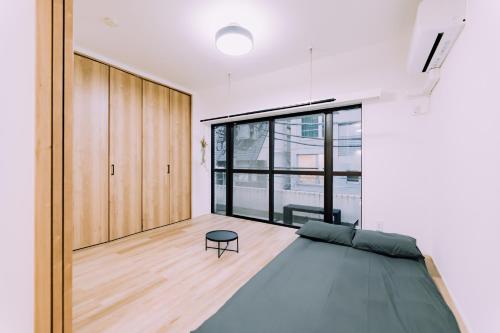 Un dormitorio con una cama y una ventana grande. en Showa Bloom Shinjuku 3, en Tokio