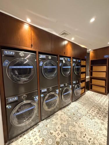 a row of four washing machines in a room at Nostalgia S Hotel Beijing National Stadium-Bird's Nest in Beijing