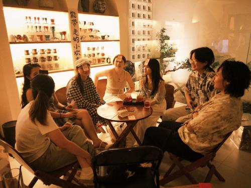 a group of people sitting around a table in a room at Eden Yard Boutique Hotel in Xianghu