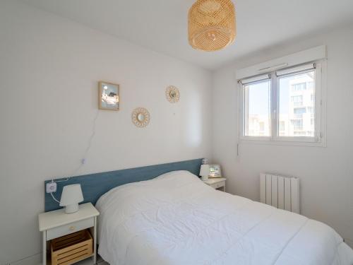 ein weißes Schlafzimmer mit einem Bett und einem Fenster in der Unterkunft Appartement 6 pers., vue océan, Mimizan Plage, parking - FR-1-50-158 in Mimizan