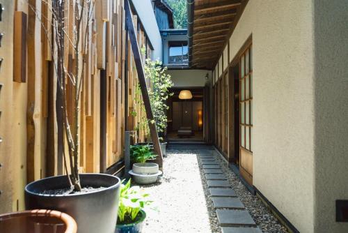 an alley with potted plants on the side of a building at 水と翠 in Gujo