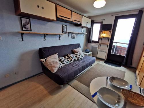 a living room with a couch and a table at Studio rénové, balcon vue vallée, proche centre et remontées - FR-1-771-1 in Les Adrets