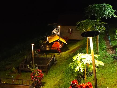 a backyard at night with a tent and flowers at Natural House Farm Stay in Môndól Kiri