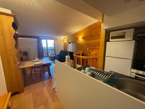 普华露Appartement familial à Pra-Loup 1600 proche des pistes - FR-1-165A-209的厨房配有水槽、冰箱和桌子