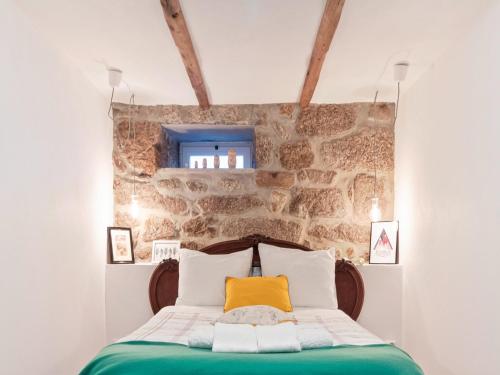 ein Schlafzimmer mit einem Bett mit einer Steinwand in der Unterkunft Mansion in Vale Abrigoso - Mezio with Patio in Vale Abrigoso