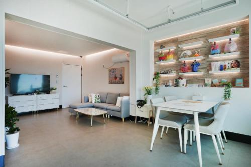 a living room with a table and a couch at Pension Haneul Tari in Jeju