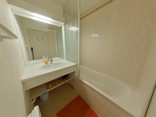 a bathroom with a sink and a mirror and a tub at Charmant appart. 6 pers, loggia vitrée aux Rousses - FR-1-834-7 in Les Rousses