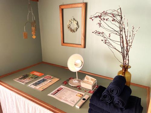 ein Tisch mit einer Lampe, einem Ventilator und einer Vase in der Unterkunft cotomaro 305 -Apartment Stay Near Matsumoto Castle- in Matsumoto