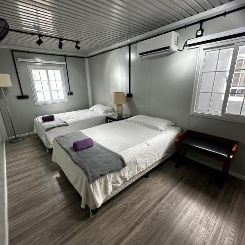 two beds in a room with two windows at Orchid Cabin Kuala Tahan in Kuala Tahan