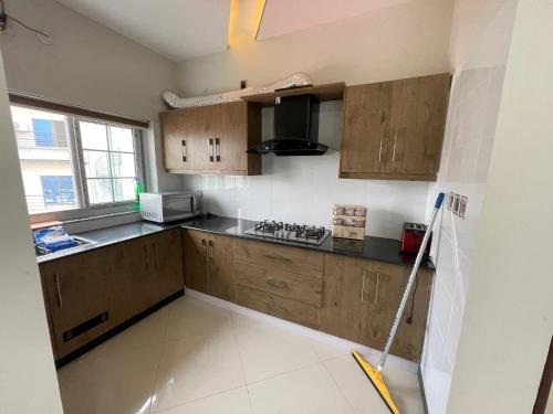 a kitchen with wooden cabinets and a mop at Ranim Family Lodge Abbottabad in Abbottābād