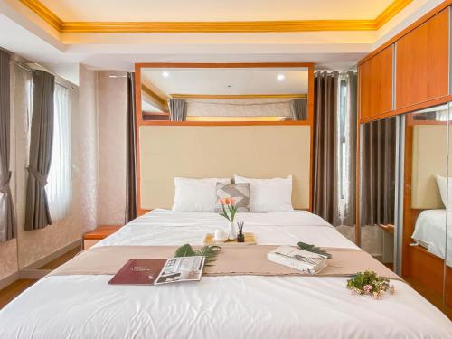une chambre avec un grand lit dans une pièce dans l'établissement Good Place and Spacious Studio Transpark Cibubur Apartment By Travelio, à Depok